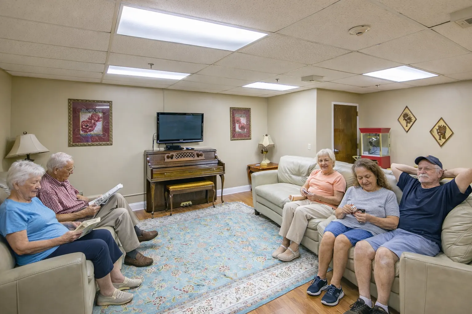 Residents reading and talking in the family room at Front Porch of Bowdon